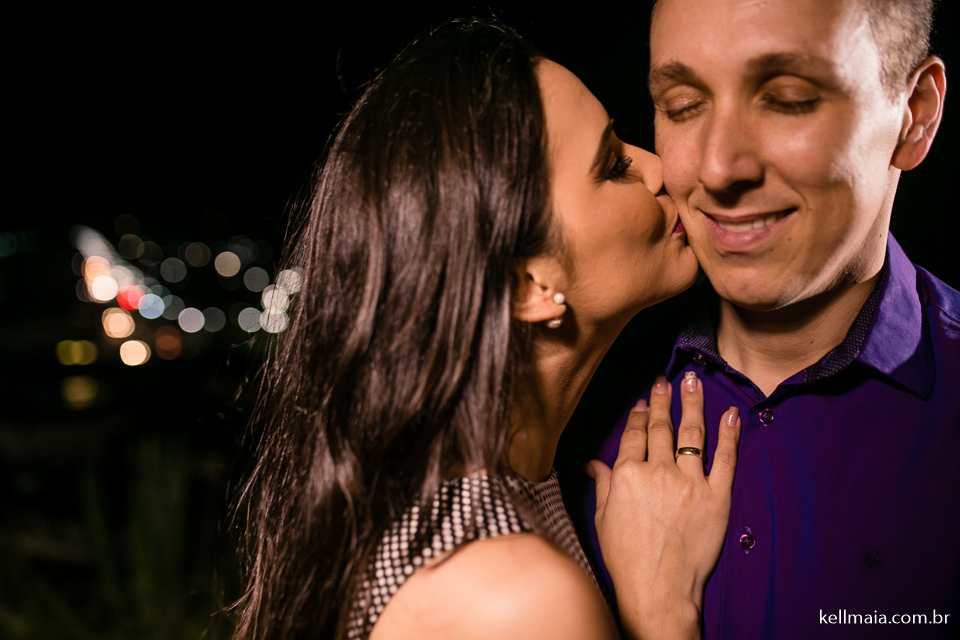 casal e nova almeida ao fundo com luzes coloridas