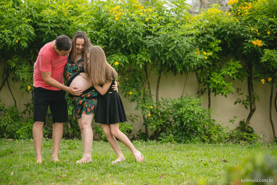 pai e filha abraçando a mamãe grávida