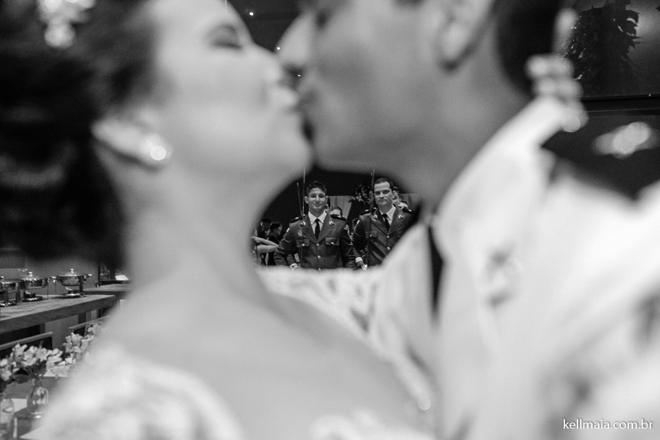 beijo dos noivos com militares ao fundo