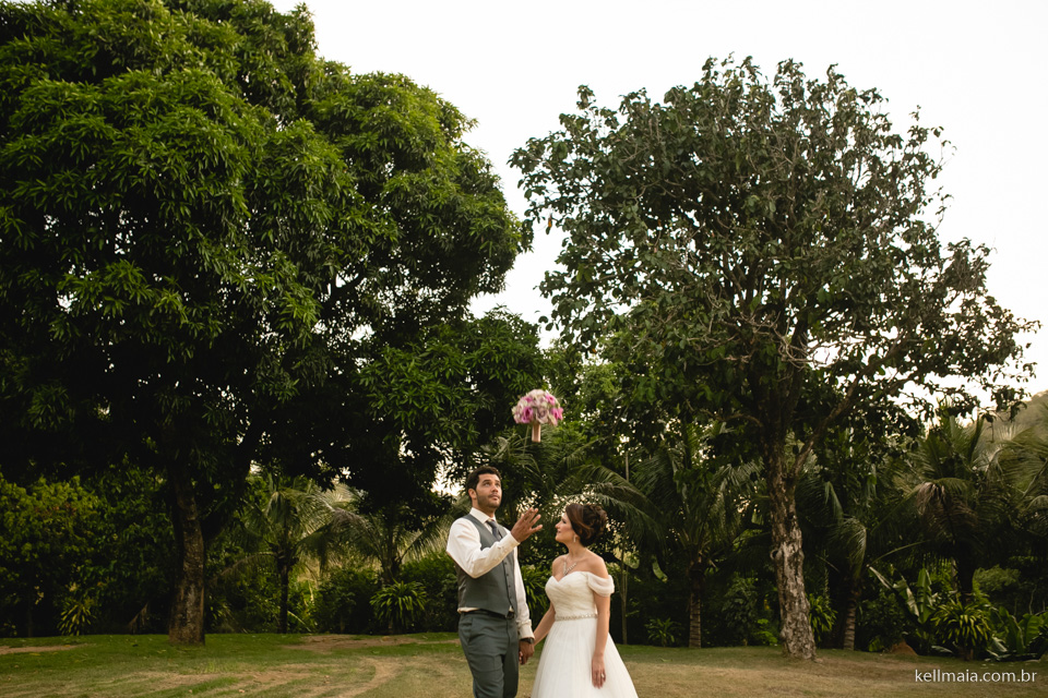 noivo jogando o buquê pro alto no campo em um sítio