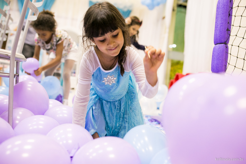 menina estourando balões