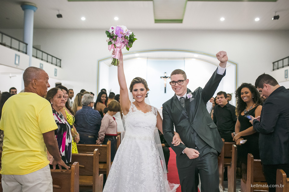 noivos alegres e sorridentes saindo da cerimônia