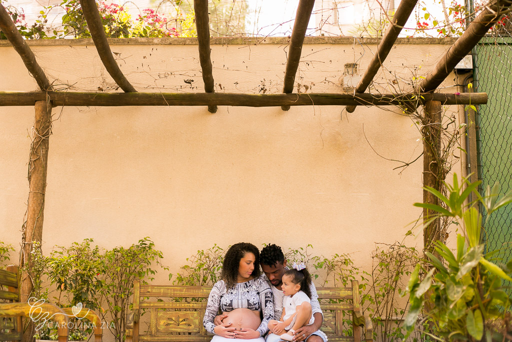 família em sessão gestante no Tatuapé em pergolado e banco de madeira bege verde