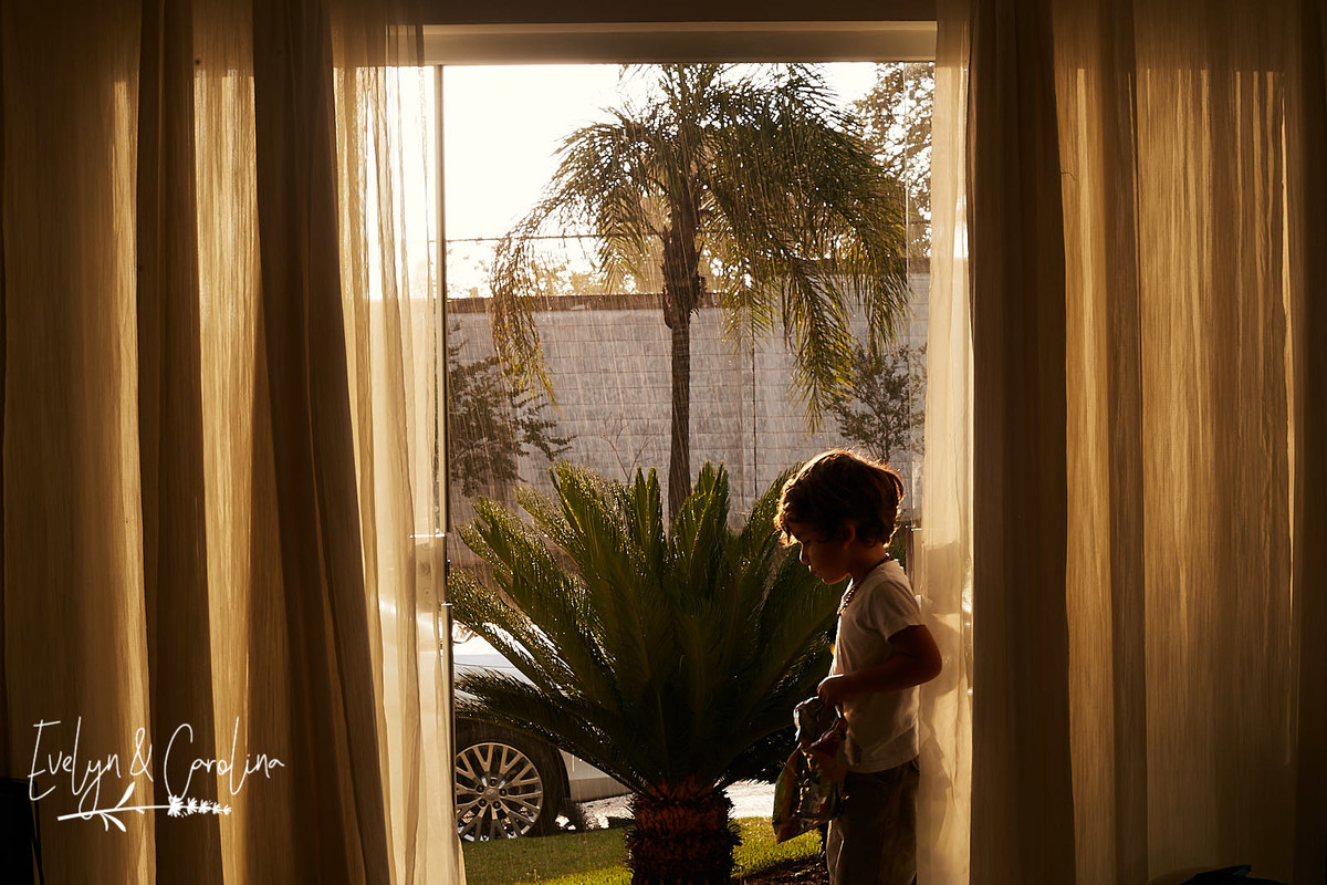 irmãos observam a chuva enquanto estão sentados na janela