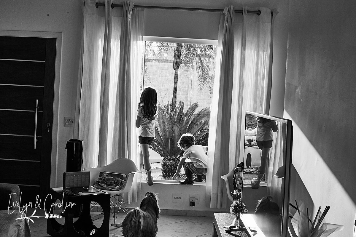 retrato da sala e das crianças que observam a chuva pela janela