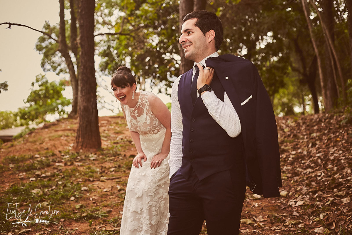 noiva ri ao ver seu noivo sério para tirar foto de casamento no campo em Itatiba interior de São Paulo