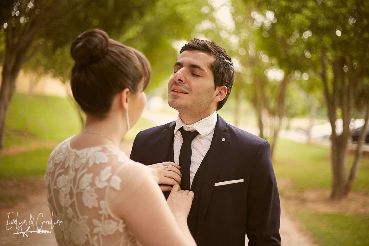 noiva arruma a gravata do noivo para início da sessão de fotos