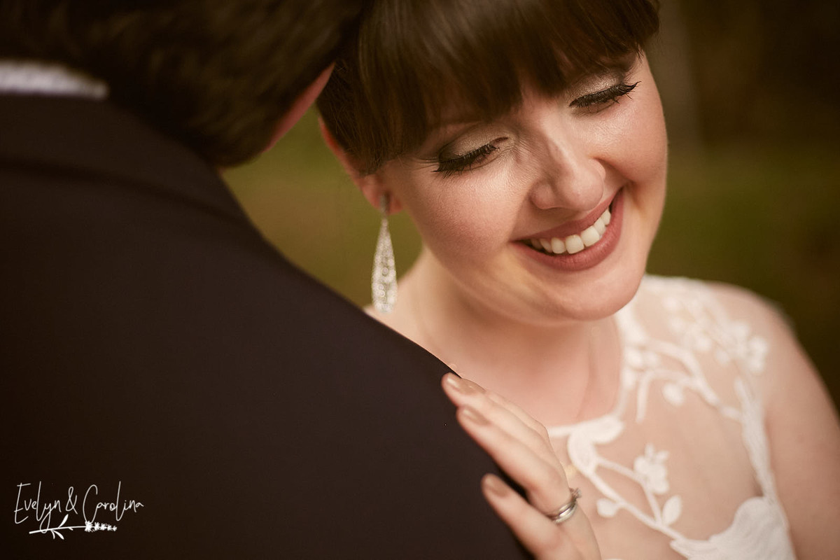 noiva sorri ao abraçar seu noivo marido