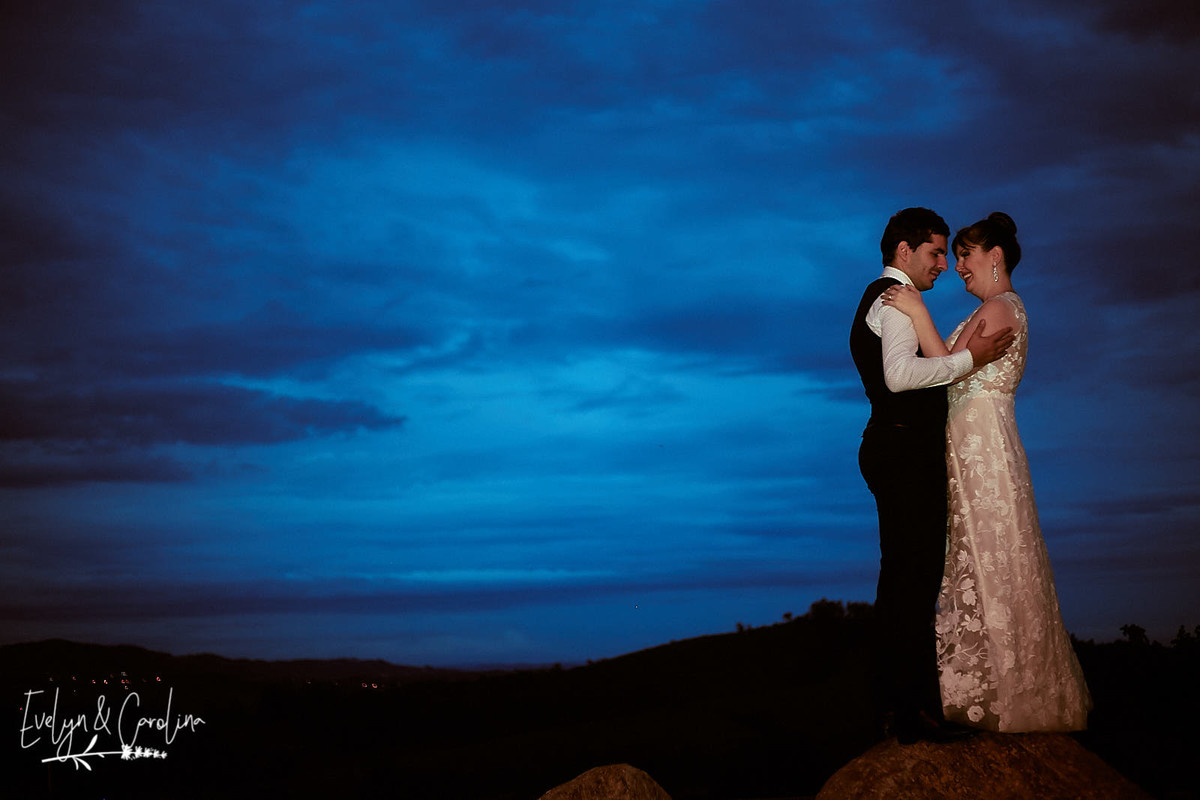 noivos se abraçam ao por do sol em sessão de fotografia após o casamento no campo em são paulo