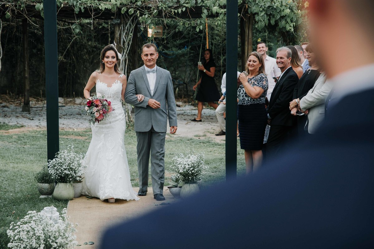 entrada da noiva no casamento na praia com uma decoração linda