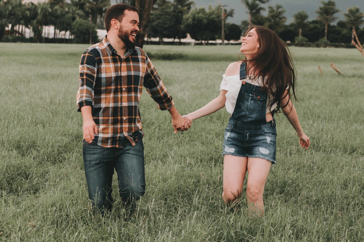 Noivos correndo no campo