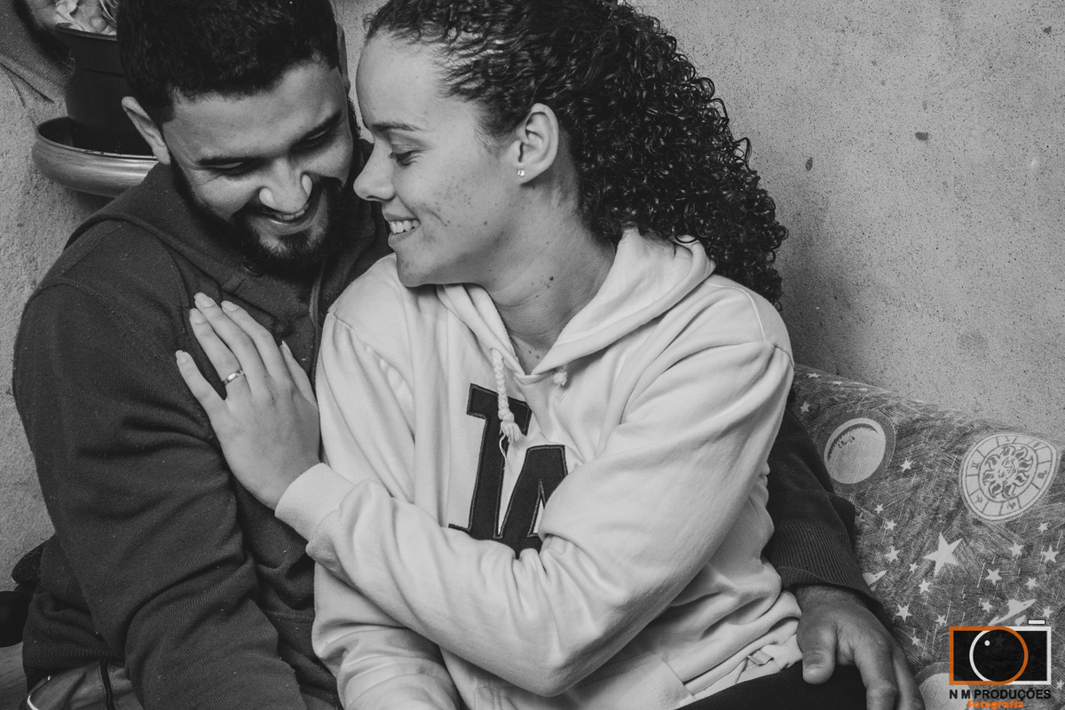 Casal Marina e Welington abraçados sorrindo no sofá