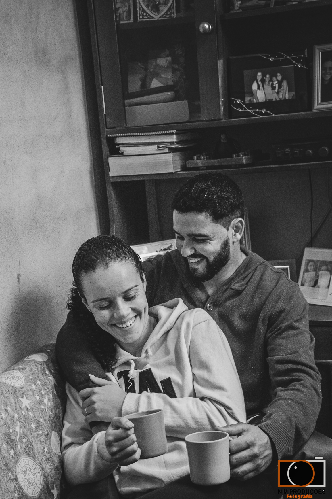 Casal Marina e Welington no sofá tomando café sorridentes