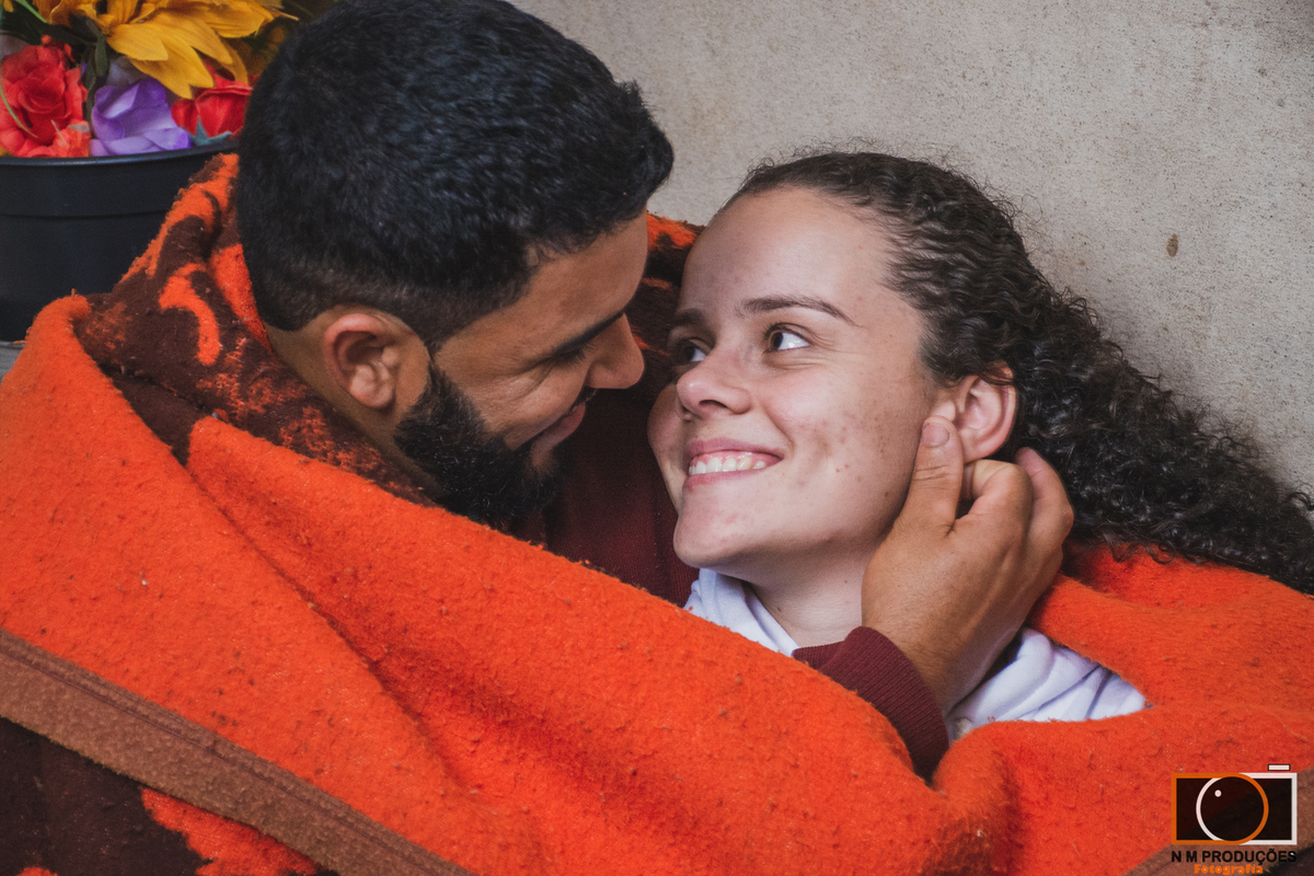 Casal Marina e Welington no sofá abraçados com o cobertor
