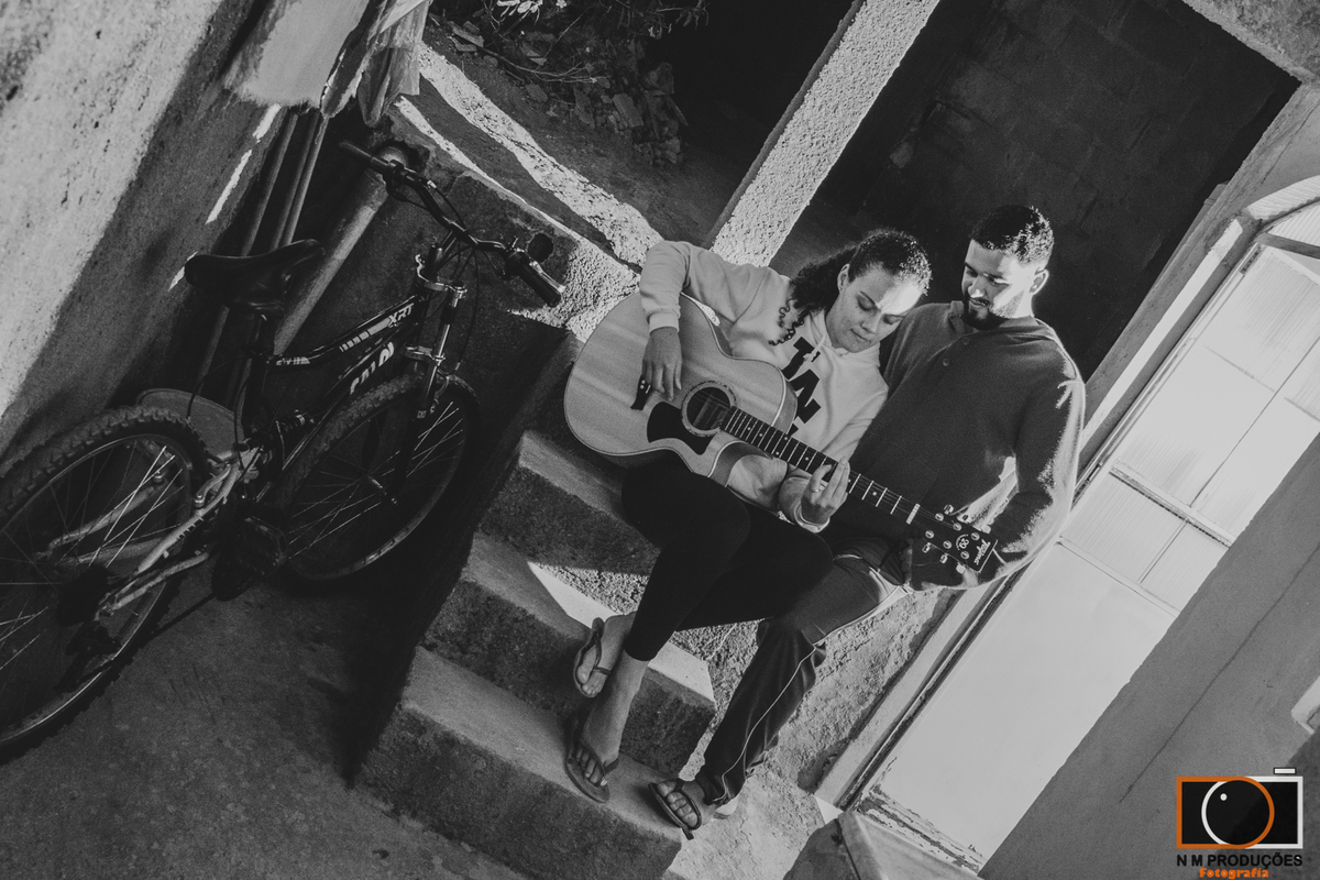 Casal Marina e Welington na varanda tocando violão