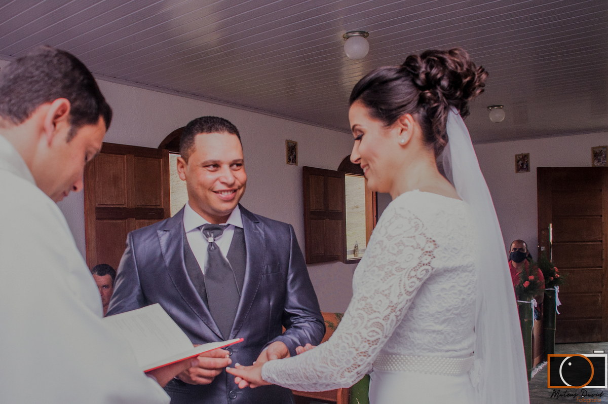 Casamento de Caroline e Adilson noivo sorrindo com alianças