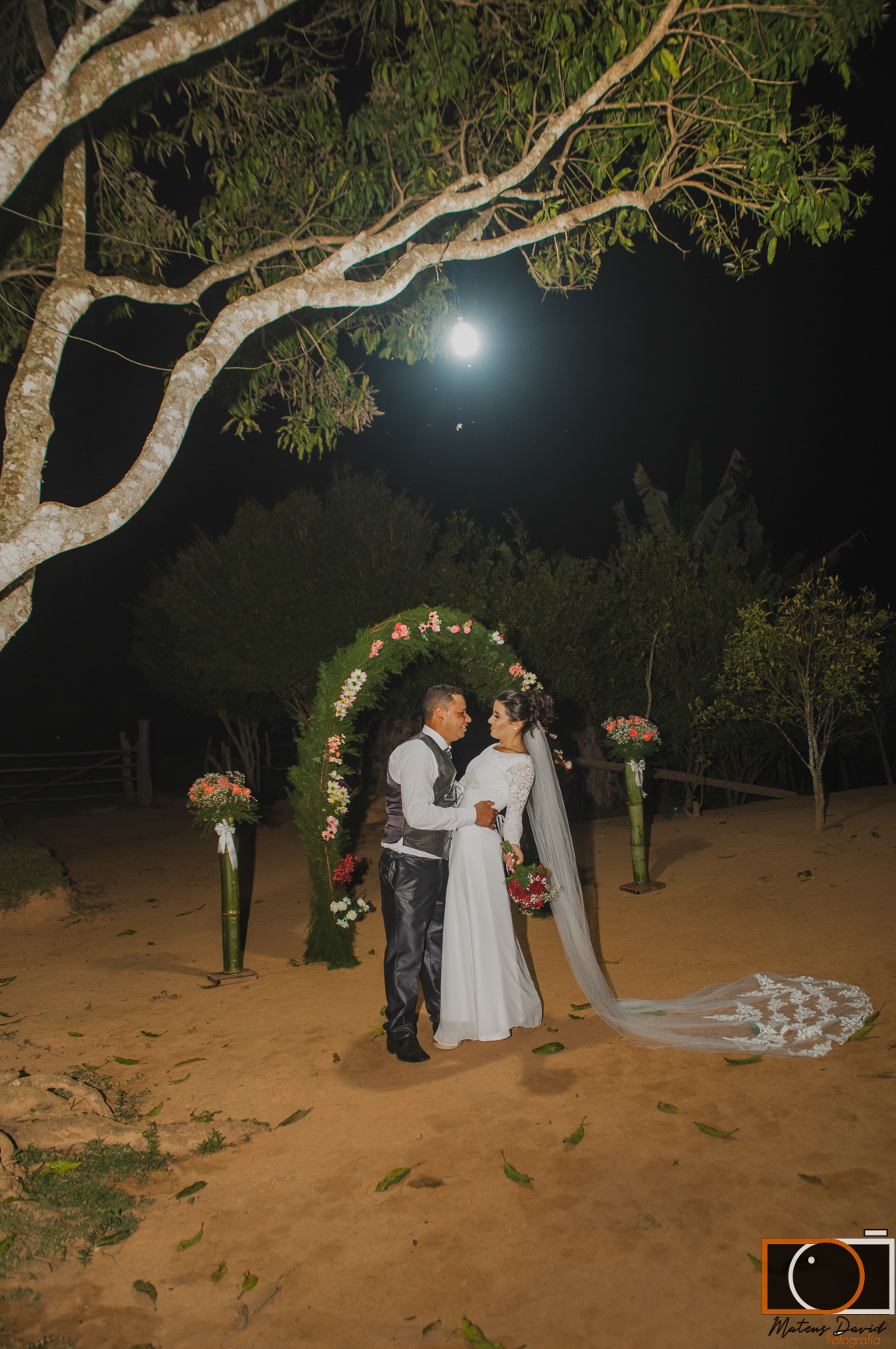 Casamento de Caroline e Adilson pose no arco perto da árvore