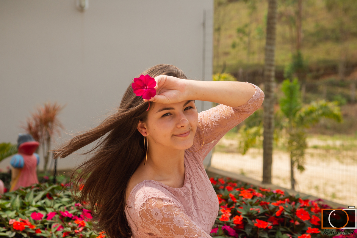 Raissa 15 Anos sorrindo com rosa no rosto