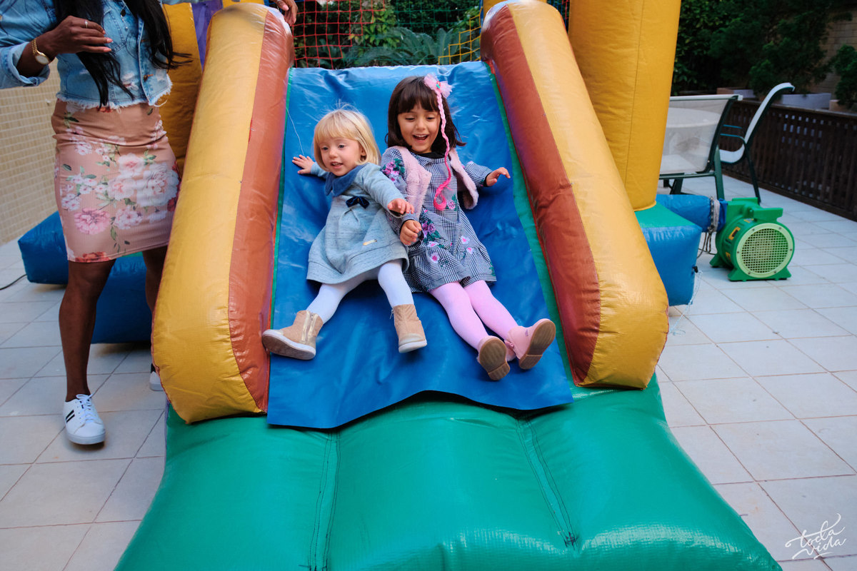 as irmãs Teresa e Helena brincando e descendo o escorregador juntas na festa de aniversário infantil com cobertura documental