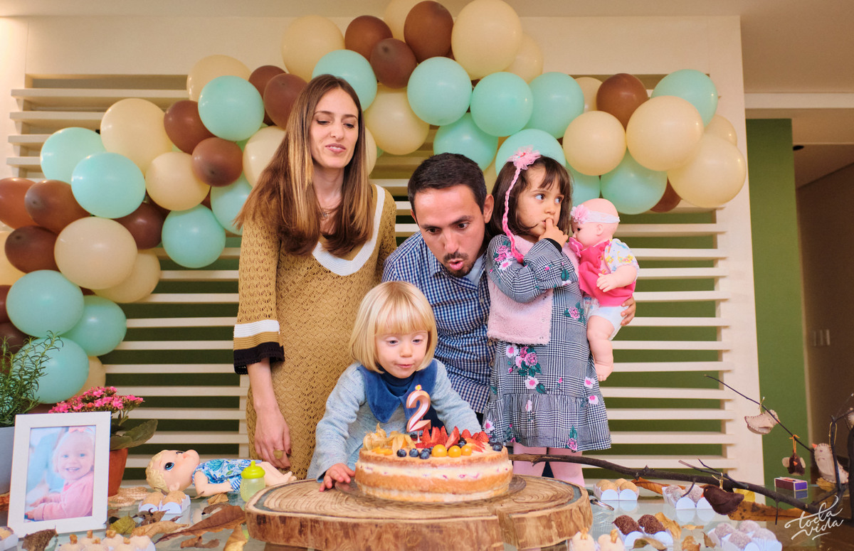papai ajudando a nenem a apagar a velinha na festa