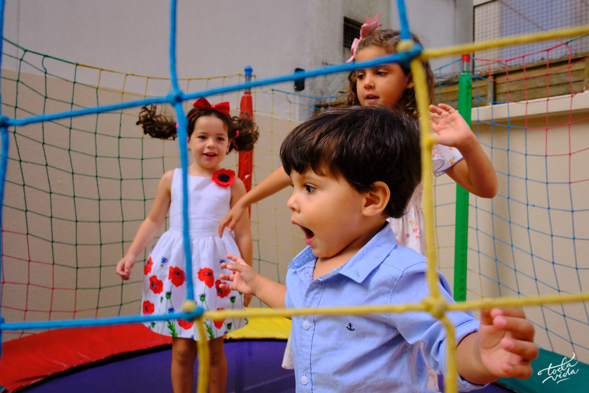 aniversariante, amiga e prima brincando no pula pula na festa de aniversário infantil