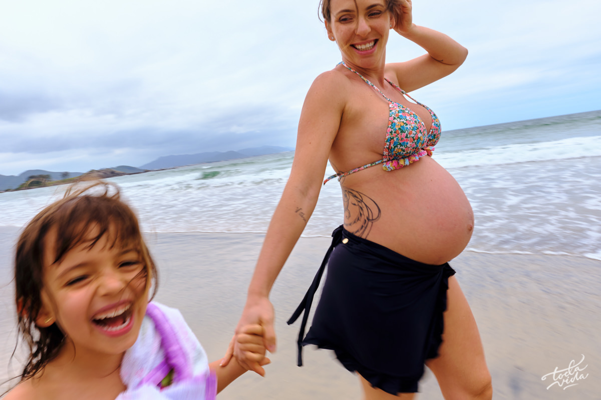 sorriso gostoso da criança Vitória que se divertiu muito na sessão de fotos de gestante na praia no sul da ilha de Floripa