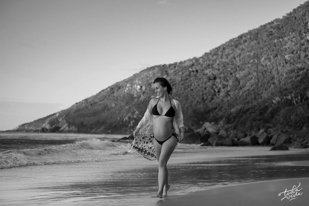 gravida de biquini caminhando na praia ao amanhecer em Floripa