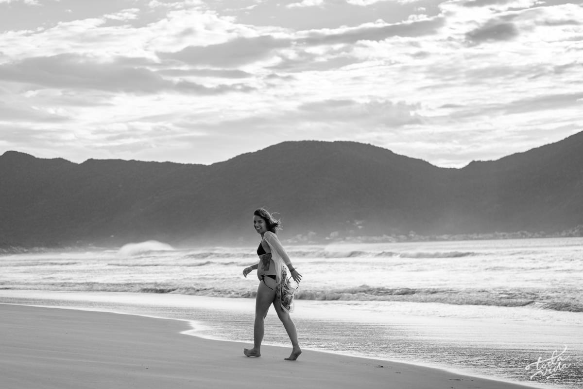 gravida de biquini caminhando na praia ao amanhecer em Floripa