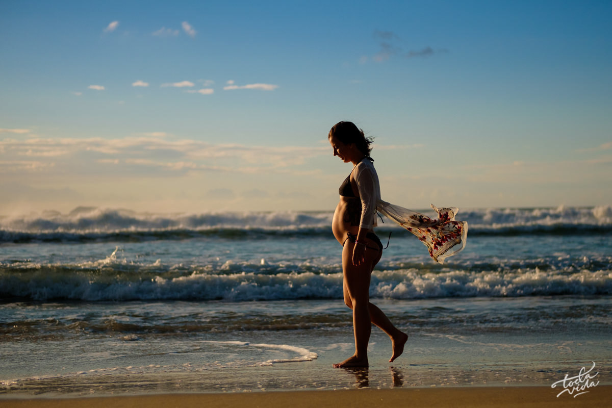 Manu gravida de biquini caminhando na praia ao amanhecer em Floripa