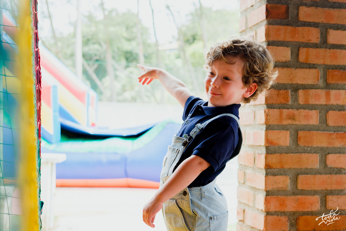 Bernardo se diverte e aponta para o brinquedo na sua festa de aniversário infantil de 4 anos