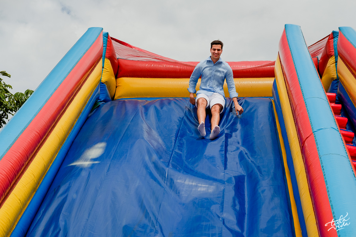 pai Eduardo brincando no escorregador na festa infantil de seu filho