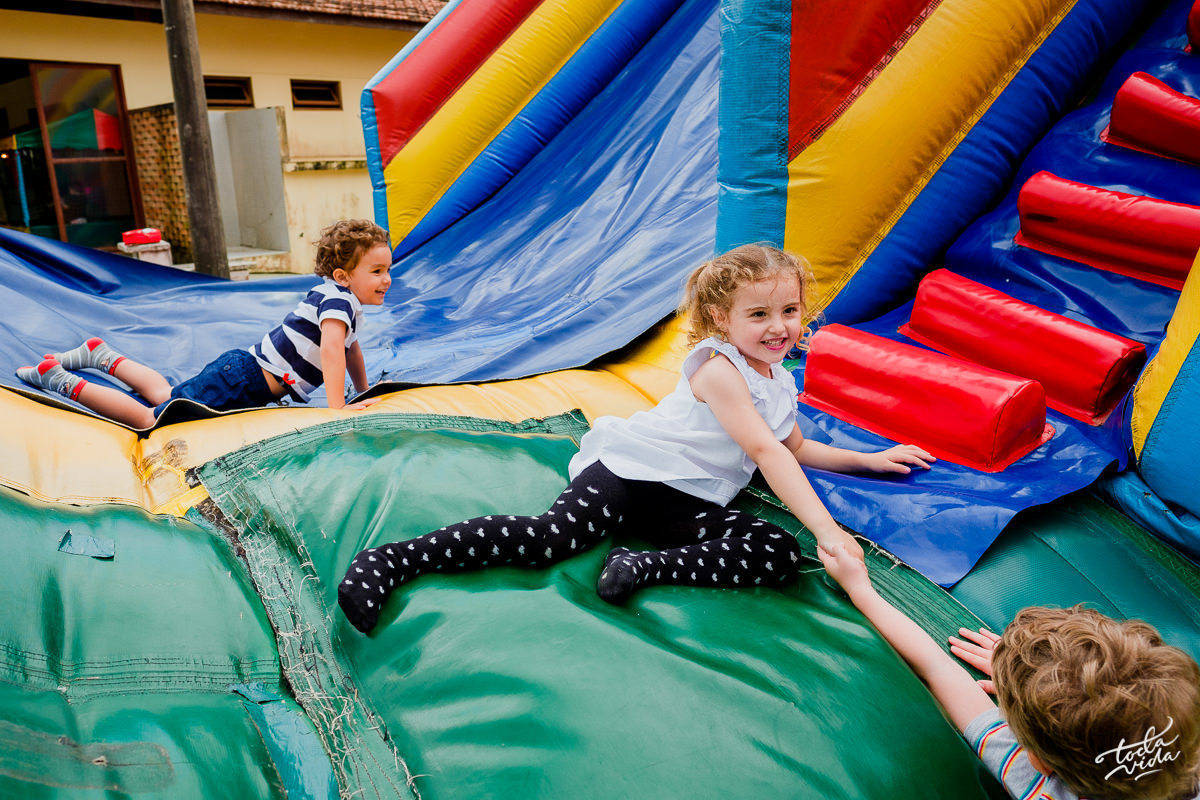criança feliz brincando no escorregador inflável da festa infantil em Floripa