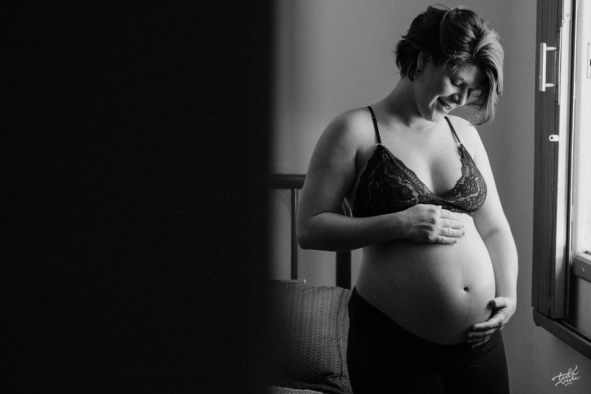 grávida Gláucia posta na janela durante ensaio gestante em casa