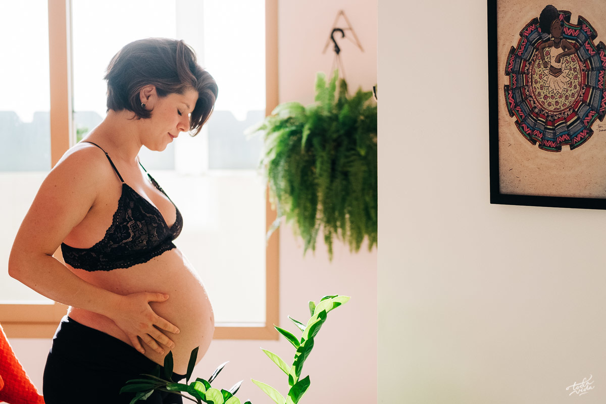 retrato de grávida com as plantas e quadros da decoração da residência da família
