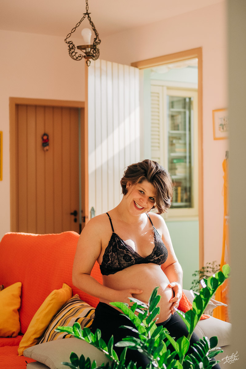 gestante Glaucia em sessão fotográfica em casa no sofá da sala de estar