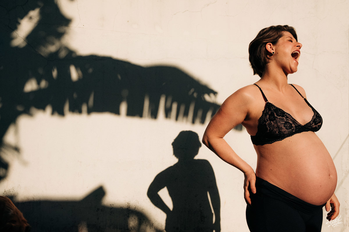 gestante linda no quintal de casa sob o sol de inverno numa sessão fotográfica despojada