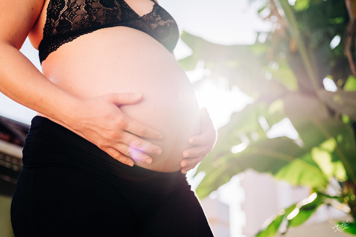 barriga de grávida em contraluz em ensaio natural em casa