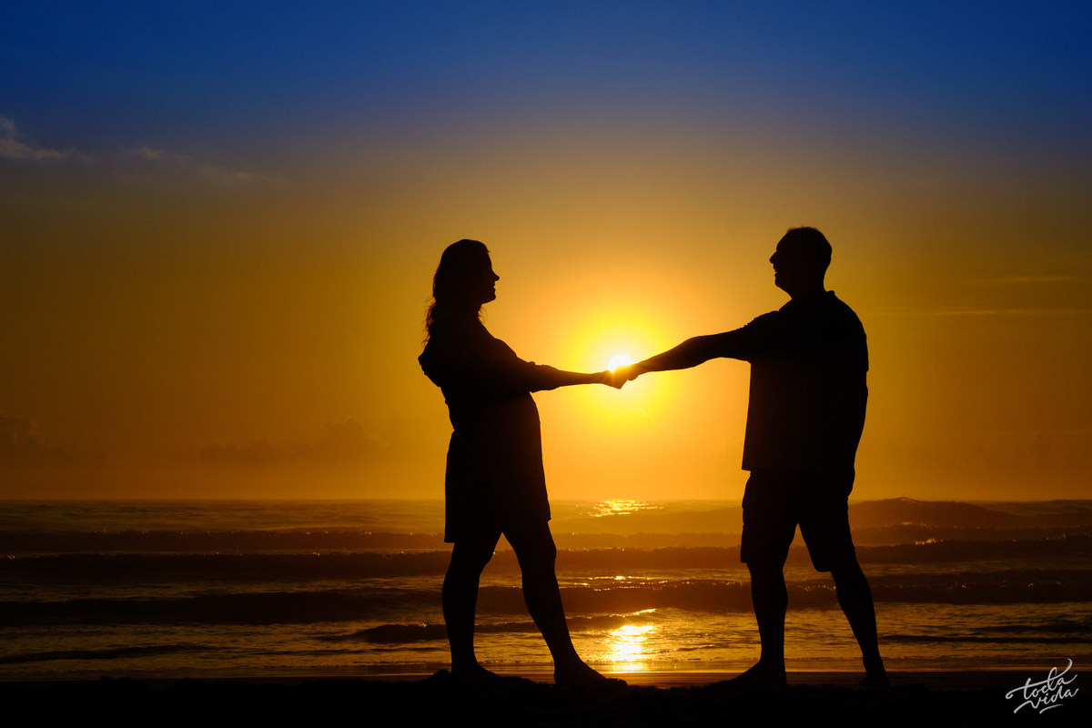 silhueta do casal em ensaio de grávida no nascer do Sol da Praia Brava em Floripa