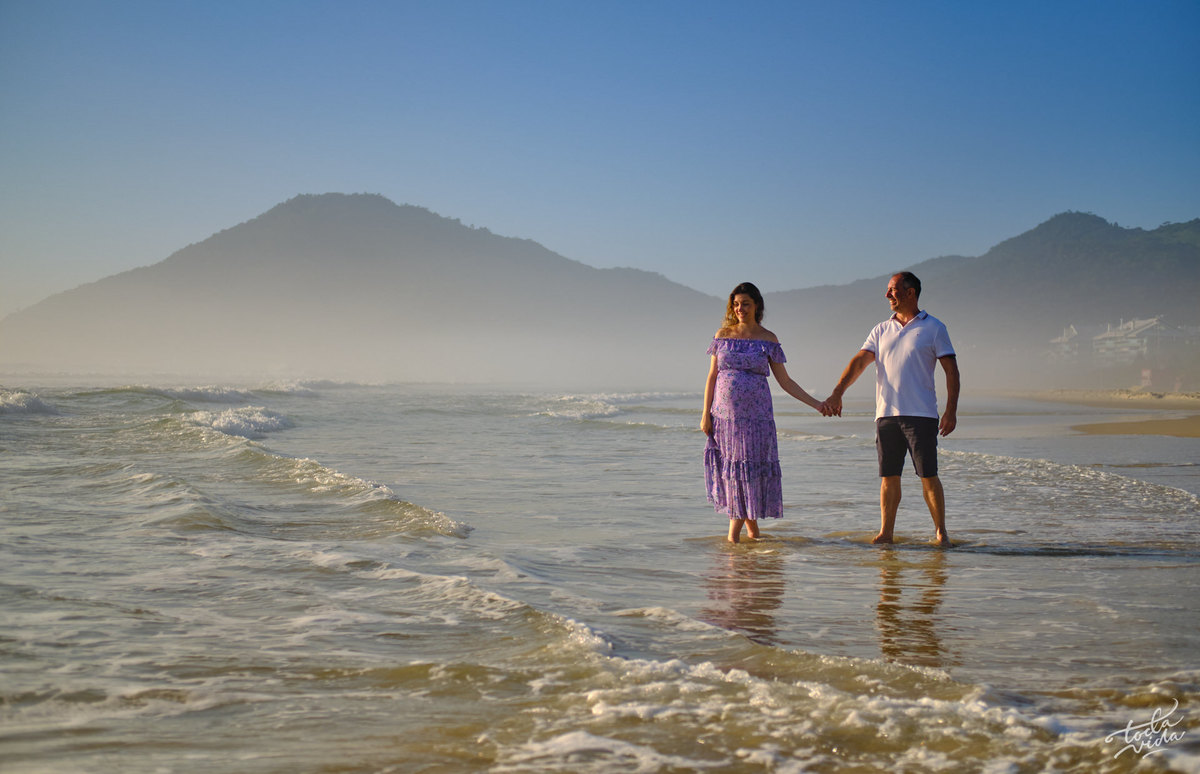 casal caminha na beira do mar durante sessão de fotos gestante em Florianópolis