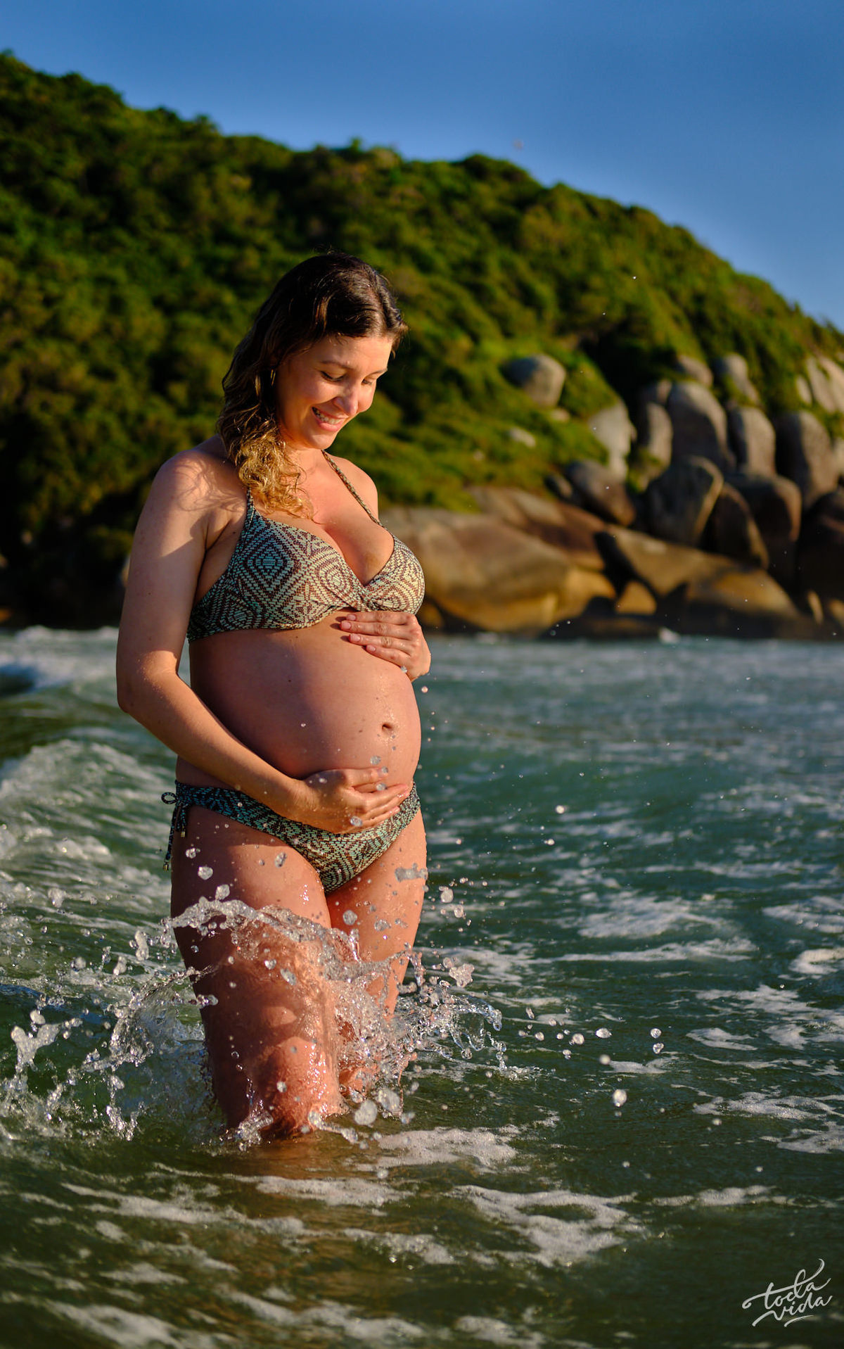 retrato da grávida Nadia se banhando de biquini na Praia Brava com mar verde lindo na ilha da Magia Floripa