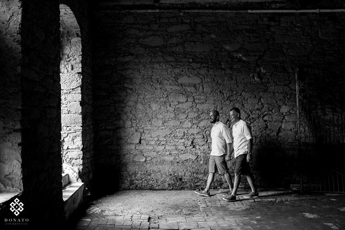 Casal de meninos, seguem em direção a porta de mãos dadas.