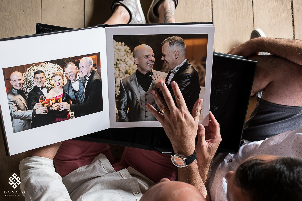 O casal vendo as fotos do casamento no album.