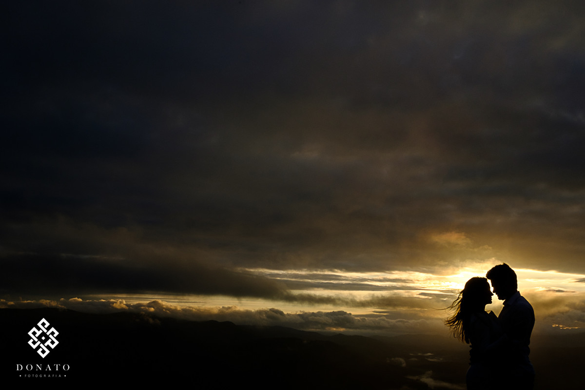 Retrato em silhueta do casal com o sol nascendo ao fundo da cidade de mairiporã.
