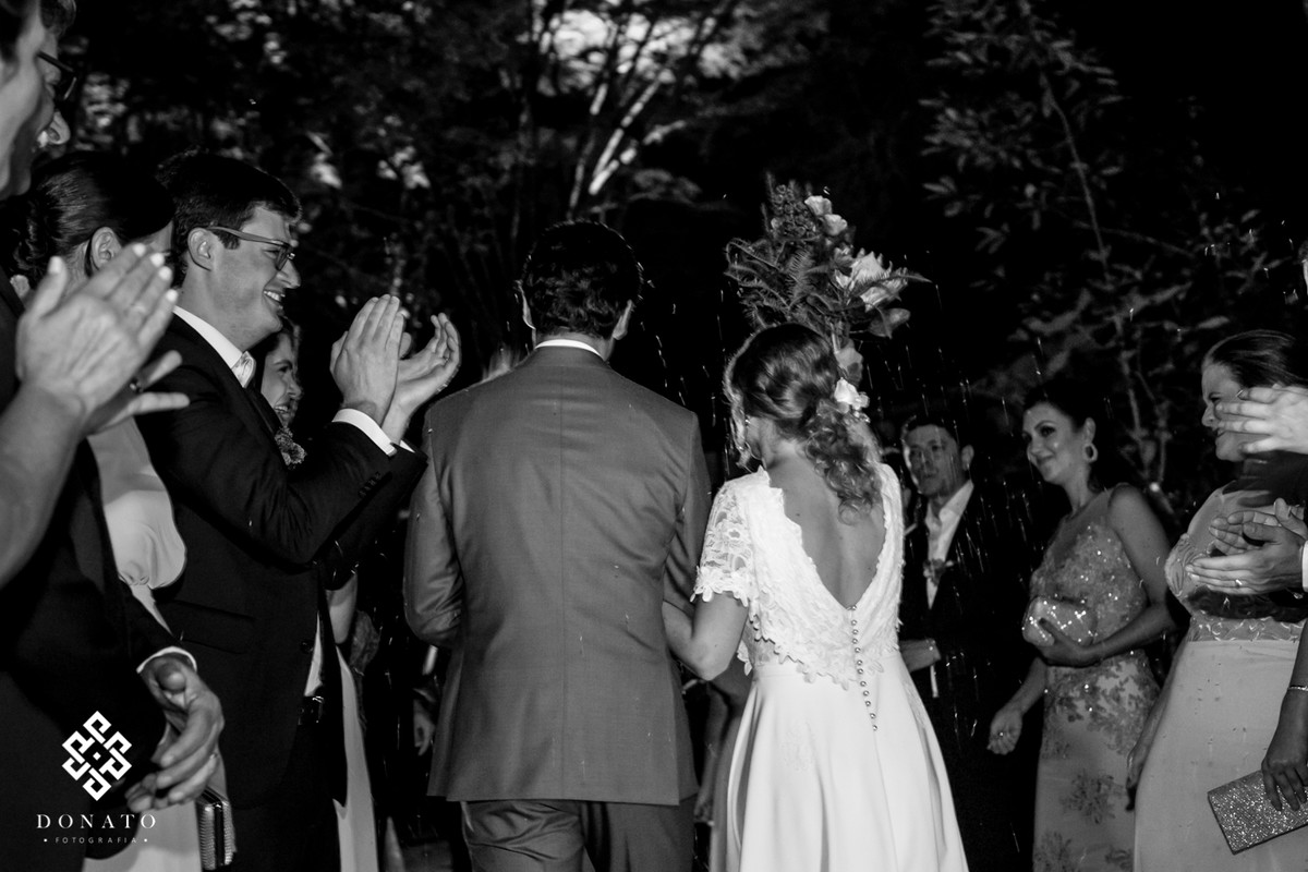 Noivos saem da cerimonia com chuva de arroz.