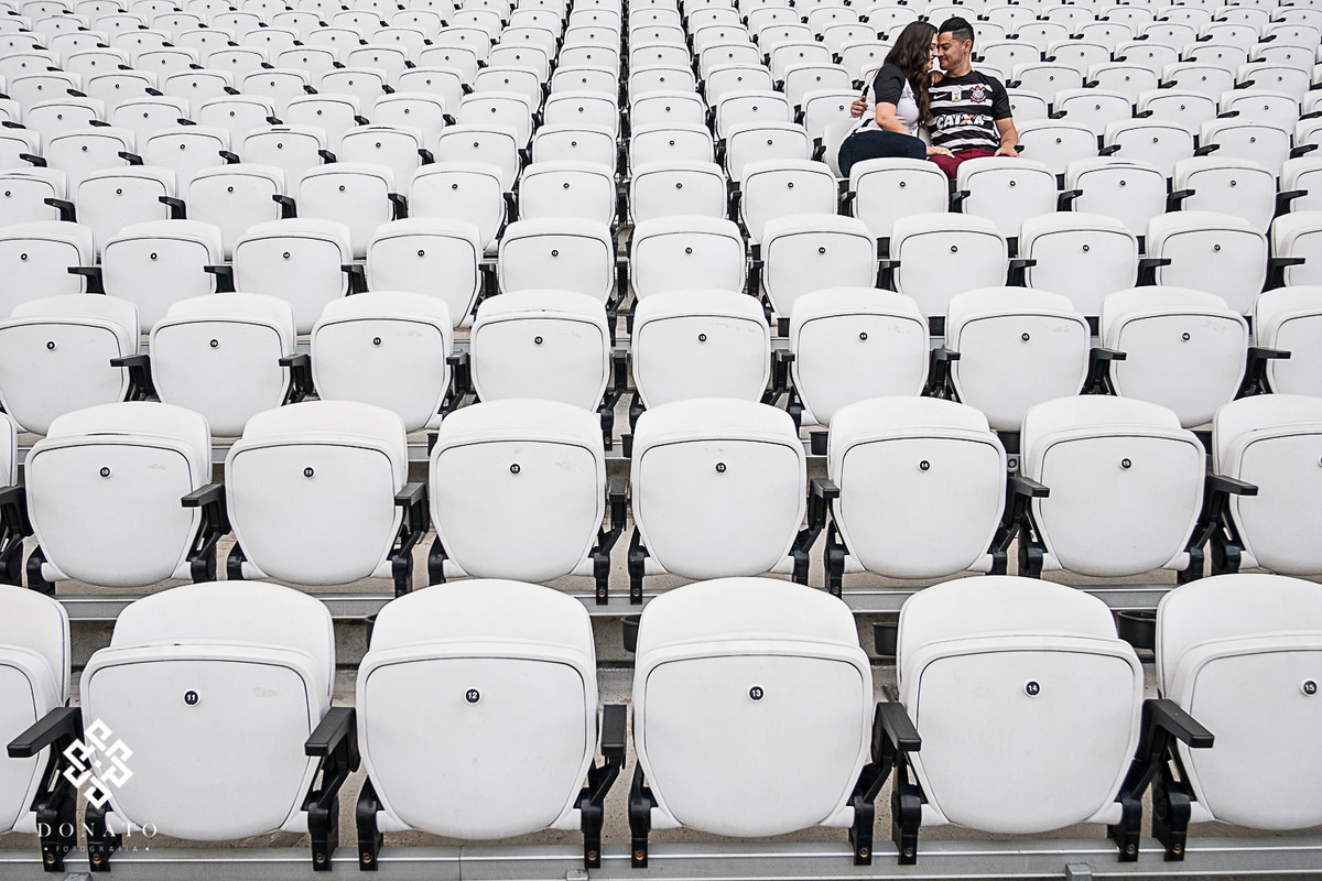 foto do casal sentado na arquibancada sozinhos.