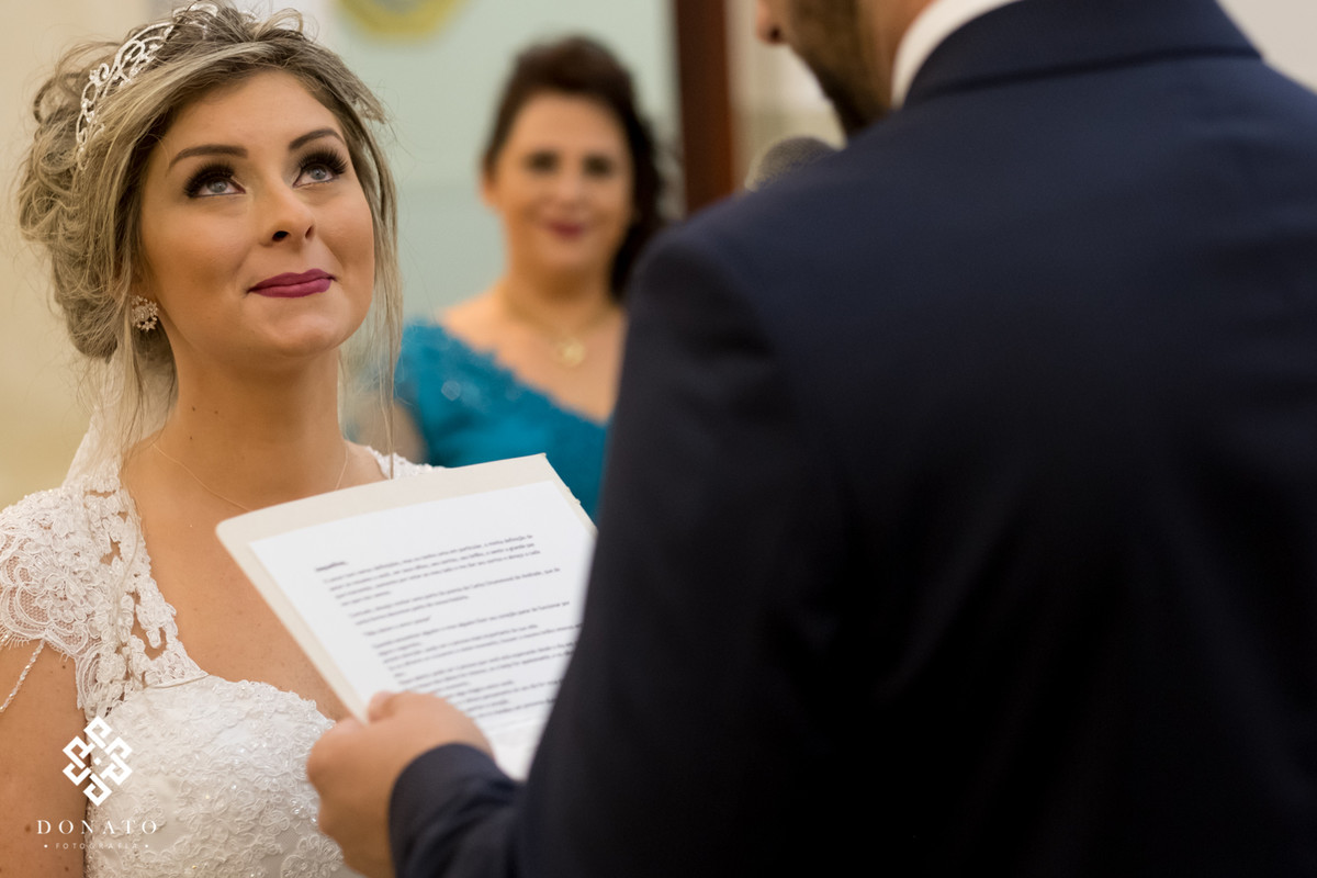 A noiva respira fundo para não chorar de eoção, enquanto o noivo Mateus lê seus votos.