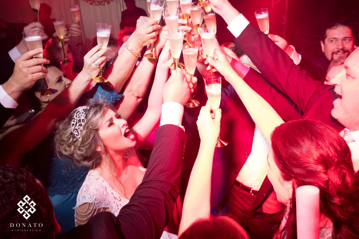 Noivos fazem um brinde com todos os padrinhos da festa.