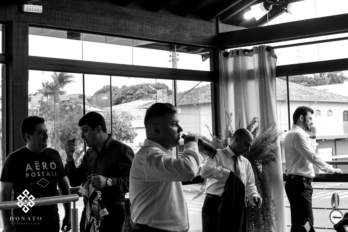 Noivo toma uma cerveja com os padrinhos antes do casamento.