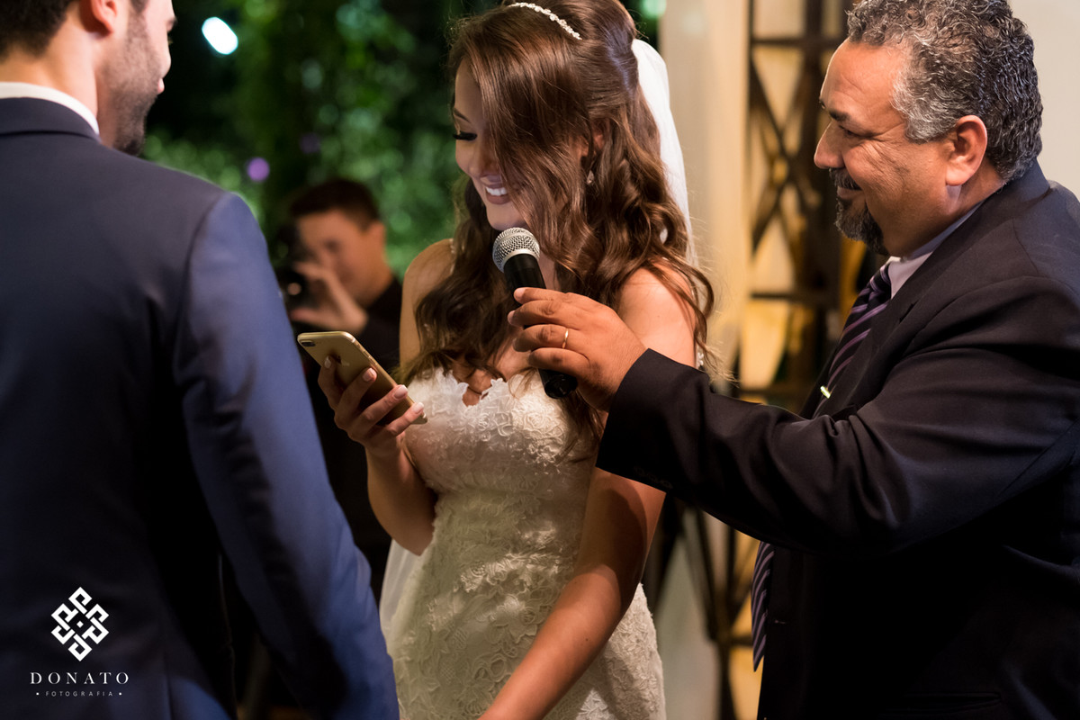 Noiva le os votos ao noivo que fica emocionado.