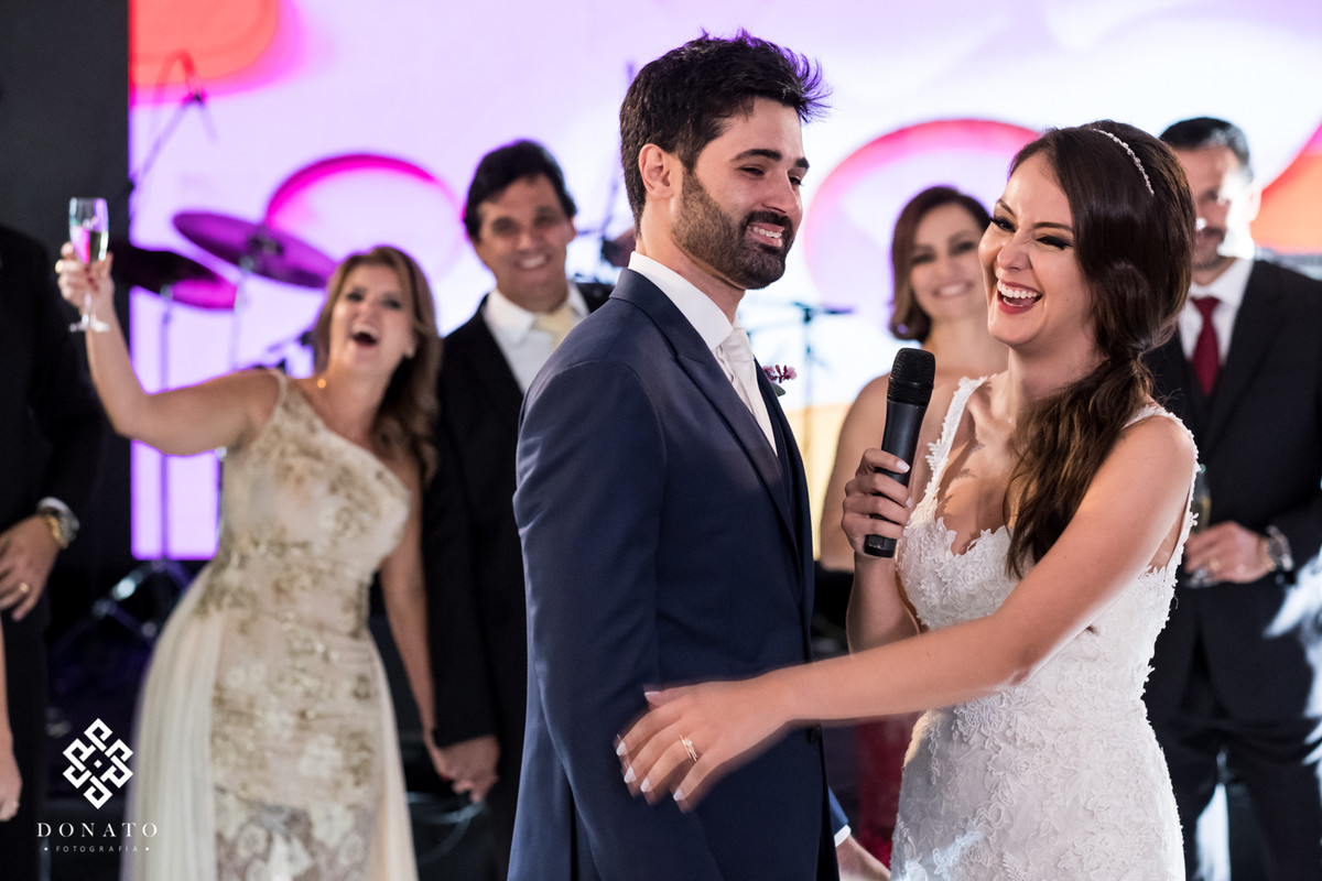 Noivos agradecem aos convidados no microfone.